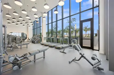 a gym with several treadmills and machines and windows at NOK Amazing 1 BR in Miami Beach in Miami Beach