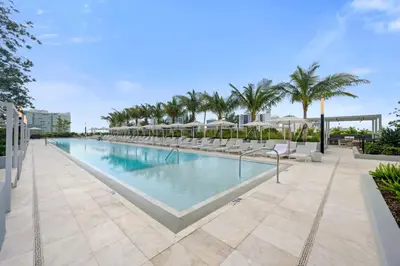 a swimming pool with chairs and palm trees at NOK Amazing 1 BR in Miami Beach in Miami Beach
