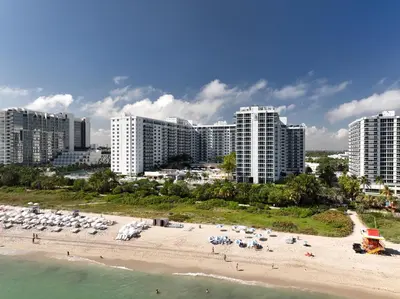 a beach with chairs and umbrellas in front of buildings at South Beach Luxury 2 Bedroom Condo on the Ocean in Miami Beach