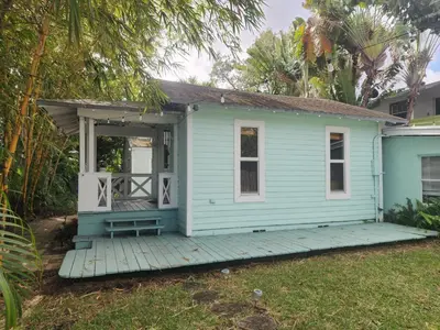 a blue house with a porch on a deck at LUSH TROPICAL STUDIO in FT LAUDEDALE'S HISTORICAL SAILBOAT BEND NEIGHBORHOOD in Fort Lauderdale