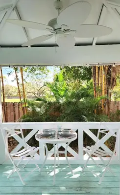 a white table and chairs on a porch at LUSH TROPICAL STUDIO in FT LAUDEDALE'S HISTORICAL SAILBOAT BEND NEIGHBORHOOD in Fort Lauderdale