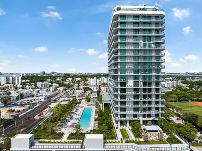 an aerial view of a tall building with a pool at 72 Park- Luxury Condo With Private Beach Access in Miami Beach
