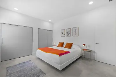 a white bedroom with a bed and a table at Villa Gabriel Modern, Family Home Just 15 minutes downtown Miami in Miami
