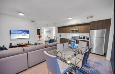 a living room with a large couch and a kitchen at Downtown Miami Excape in Miami