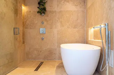 a bathroom with a white tub and a shower at Amazing Ocean and 1 Hotel pool Views 2BR 3BA w Balcony in Miami Beach