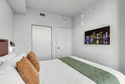 a white bedroom with a bed and a tv on the wall at Luxury 2 Bedroom Corner Unit Crosby Rooftop Pool in Miami