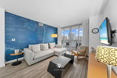 a living room with a couch and a blue wall at Peaceful Bay View Apartment Near Beach in Hallandale Beach