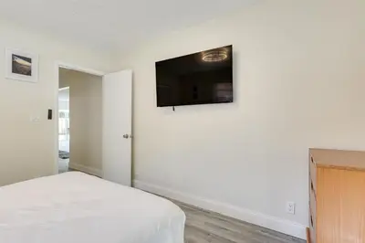 a bedroom with a bed and a flat screen tv on the wall at Walk to Shops and Eats, 3 Mi to Beach! Hollywood Gem in Hollywood