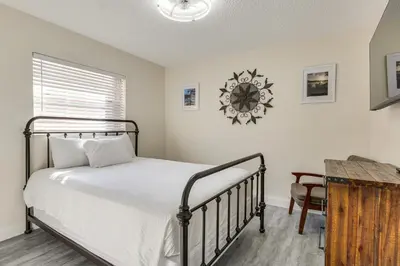 a bedroom with a bed with a clock on the wall at Walk to Shops and Eats, 3 Mi to Beach! Hollywood Gem in Hollywood