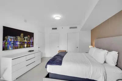 a white bedroom with a large bed and a tv at Amazing 1bed at The W icon brickell in Miami