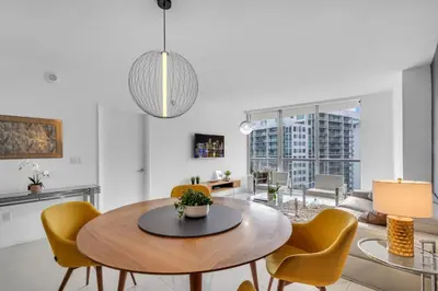 a dining room with a table and yellow chairs at Amazing 1bed at The W icon brickell in Miami