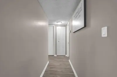 a hallway with white walls and a white door at Stylish 2BR in North Miami with Free Parking in North Miami