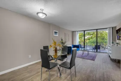 a dining room and living room with a table and chairs at Stylish 2BR in North Miami with Free Parking in North Miami