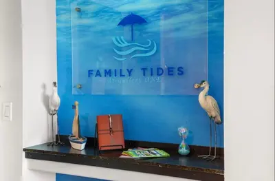 a display of birds on a counter with a sign at Family Tides At GalleryOne in Fort Lauderdale