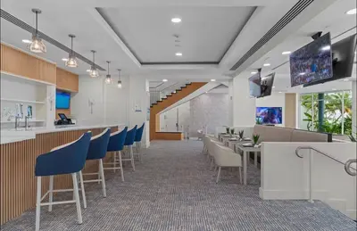 a lobby with a bar with chairs and a tv at Family Tides At GalleryOne in Fort Lauderdale