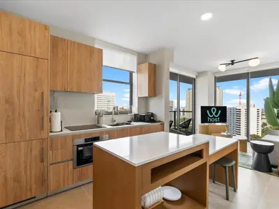 a kitchen with wooden cabinets and white counter tops at Central Downtown Condo - Rooftop Pool Access in Miami