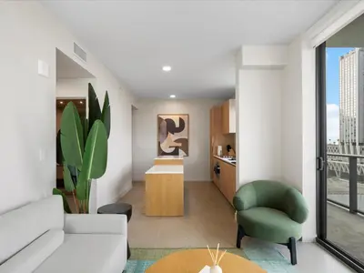 a living room with a white couch and a green chair at Central Downtown Condo - Rooftop Pool Access in Miami