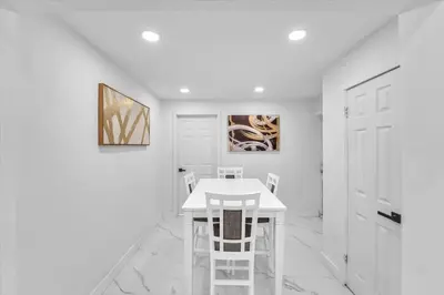 a white dining room with a white table and chairs at Oasis With Pool and Putting Green in Hollywood
