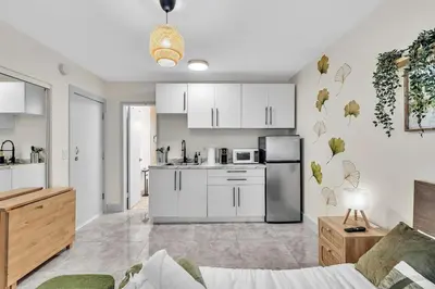 a kitchen with white cabinets and a kitchen with a refrigerator at Santorini Blu Stylish Coastal Studio on the Beach in Hollywood