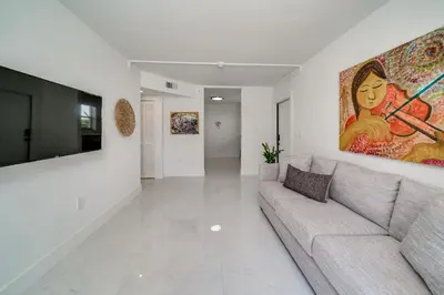 a living room with a couch and a painting on the wall at Wynwood Charm, at the Heart of the Art! in Miami