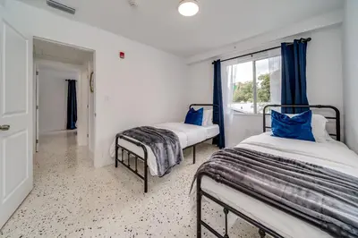 two beds in a room with a window at Wynwood Charm, at the Heart of the Art! in Miami