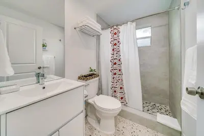 a white bathroom with a toilet and a shower at Wynwood Charm, at the Heart of the Art! in Miami