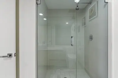 a bathroom with a shower with a glass door at Luxury Oceanview Condo with Private Foyer at Beachwalk Resort in Hallandale Beach