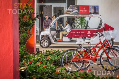 a small car with bikes parked in front of it at Luxury Oceanview Condo with Private Foyer at Beachwalk Resort in Hallandale Beach