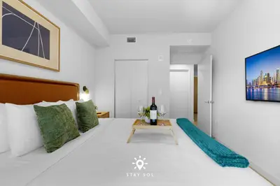 a bedroom with a bed with a bottle of wine on it at 1BR Apartment New Luxury in Miami