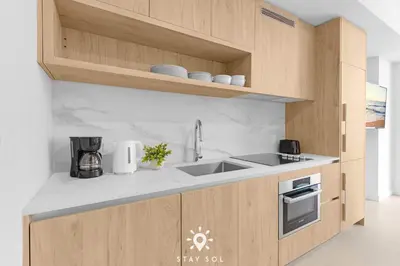 a kitchen with wooden cabinets and a sink at Stylish Miami Studio Perfect for City Living in Miami