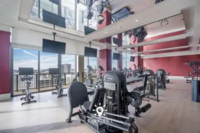 a gym with a lot of treadmills and ellipticals at Stylish Miami Studio Perfect for City Living in Miami