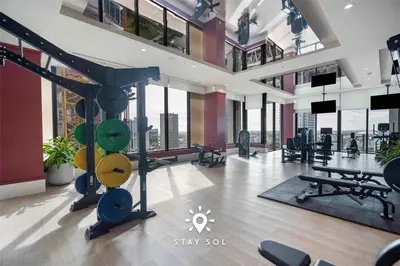 a large room with a gym with large windows at Stylish Miami Studio Perfect for City Living in Miami