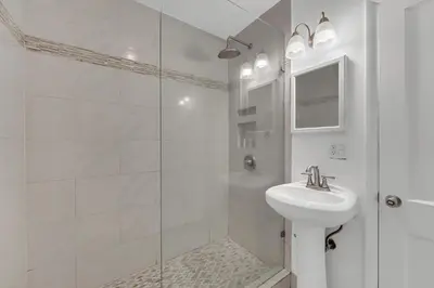 a white bathroom with a sink and a shower at Victoria Park Oasis Walk to las Olas Beach in Fort Lauderdale