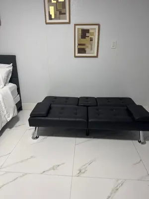 a black couch sitting in a white room at Beautiful 1 bedroom Studio located in Miramar in Miramar