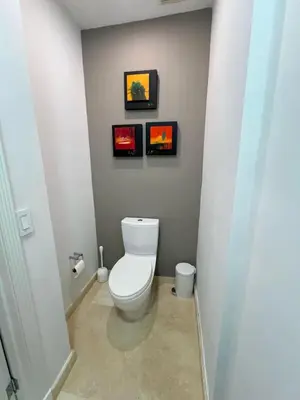 a bathroom with a toilet and three pictures on the wall at Luxury 4BR Coconut Grove Home wIith Pool and BBQ in Miami