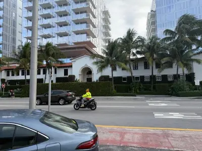 a person riding a motorcycle down a street in a city at 9064 Collins Ave 2 in Miami Beach