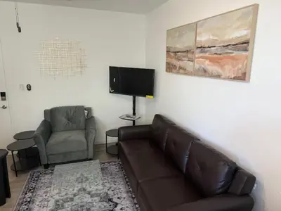 a living room with a couch and a chair and a television at 9064 Collins Ave 2 in Miami Beach