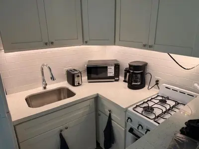 a kitchen with a stove and a sink and a microwave at 9064 Collins Ave 2 in Miami Beach