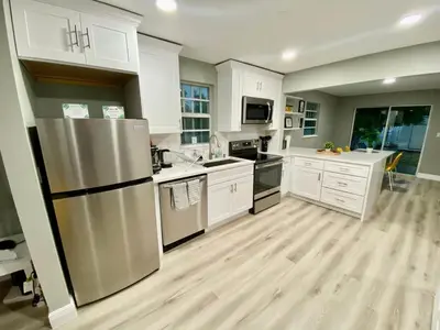 a kitchen with white cabinets and a stainless steel refrigerator at Hollywood Escape in Hollywood