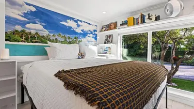 a bedroom with a bed and a large window at Casa Pineapple Social by AvantStay Spa Game Room EV Charger Near Las Olas Fort Lauderdale Beaches Sleeps 16 in Fort Lauderdale