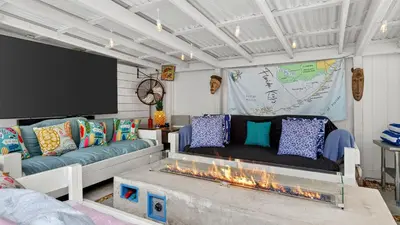 a living room with a couch and a flat screen tv at Casa Pineapple Social by AvantStay Spa Game Room EV Charger Near Las Olas Fort Lauderdale Beaches Sleeps 16 in Fort Lauderdale