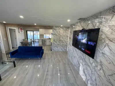 a lobby with a blue couch and a flat screen tv at Waterfront Modern Hollywood Hard Rock airport in Fort Lauderdale