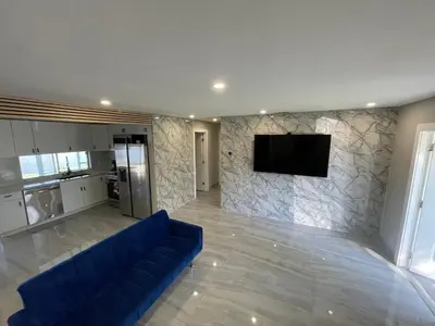 a living room with a blue couch and a tv on a wall at Waterfront Modern Hollywood Hard Rock airport in Fort Lauderdale
