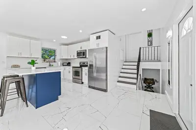 a kitchen with white cabinets and a blue island at Casa Sol - 4 Bedroom 2 Bath - 7 beds - Affordable Stays For Large Groups in Ives Estates
