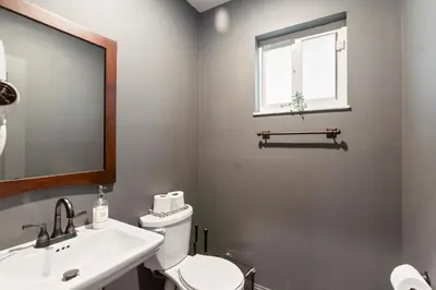 a bathroom with a toilet and a sink and a window at Heated Pool Games Family Haven Near FIU