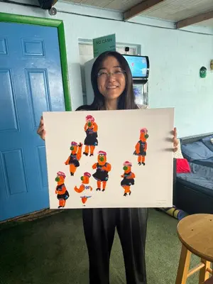a woman is holding up a picture of a mario team at Kayoma Hostel in Miami