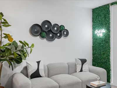 a living room with a couch and a green wall at Modern Studio by Bayside & Cruise Port in Miami