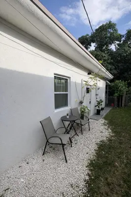 a group of chairs and tables next to a building at Quiet Studio Retreat attached to big House in Miami