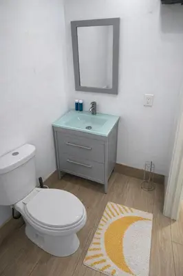 a bathroom with a white toilet and a sink at Quiet Studio Retreat attached to big House in Miami