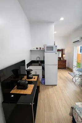 a small kitchen with a white refrigerator in a room at Quiet Studio Retreat attached to big House in Miami